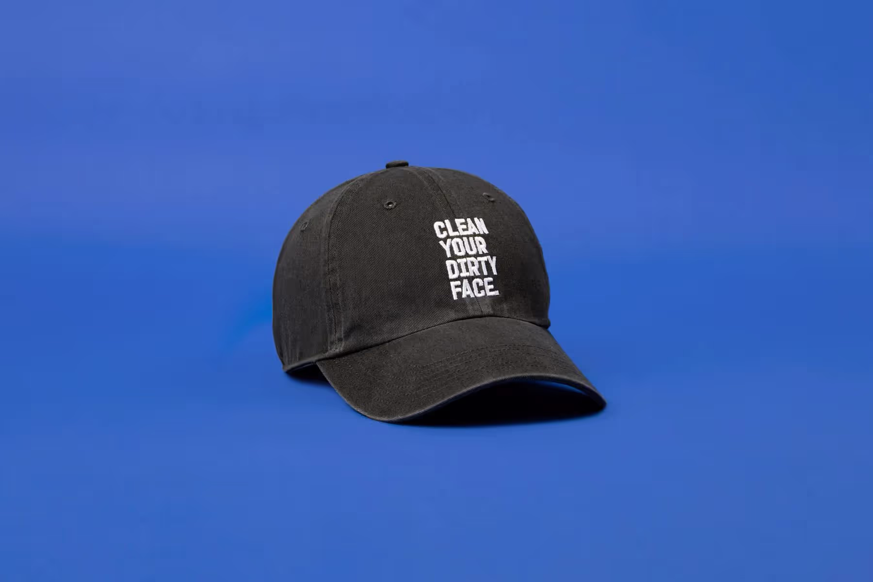 a black baseball hat on a blue backdrop